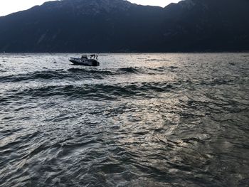 People on boat in sea against sky