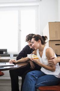 Couple eating lunch and using laptop