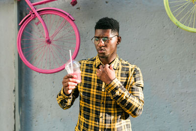 Side view of young man standing against wall