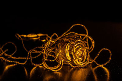 Close-up of illuminated lighting equipment against black background