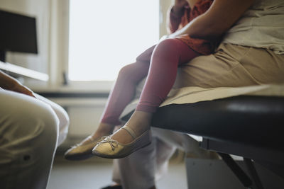 Low section of girl with mother in clinic