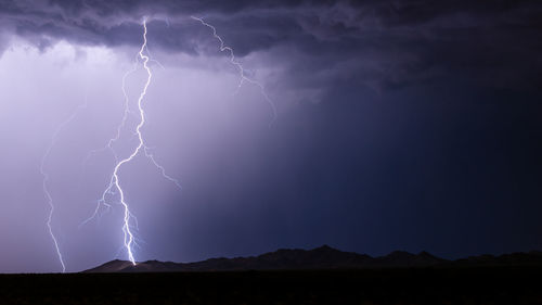 A powerful lightning bolt strikes a mountain during a monsoon storm near phoenix, arizona.