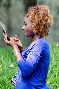 Side view of young woman using mobile phone