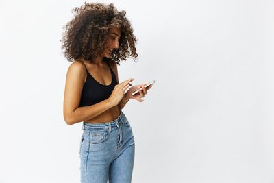 Portrait of young woman standing against white background