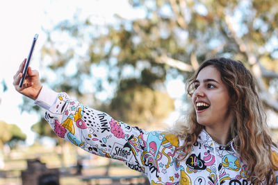 Portrait of young woman using mobile phone outdoors