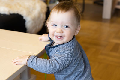 Cute baby with blue eyes is learning how to walk. high quality photo