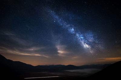 Scenic view of mountains against sky at night