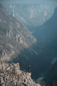 Man standing on rock by mountains