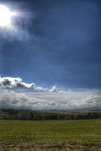 Scenic view of field against cloudy sky