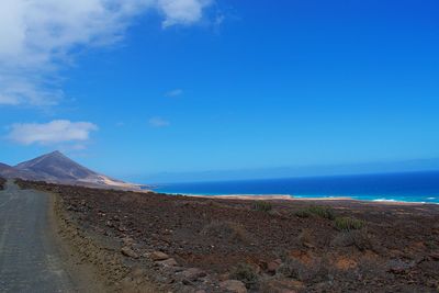 Scenic view of beach against blue sky