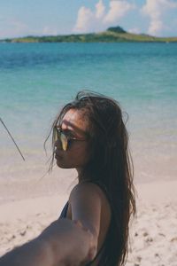 Side view of young woman wearing eyeglasses at beach