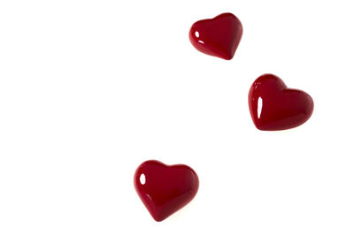 Close-up of red heart shape over white background