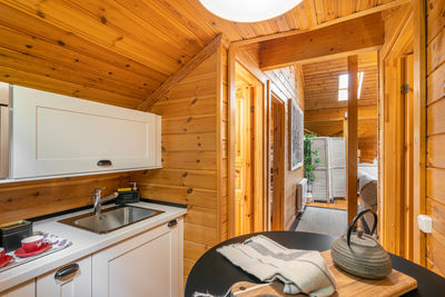 Small kitchen with compact furniture and view to the hallway in wooden house. village life concept.