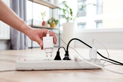 Cropped hand of woman using computer