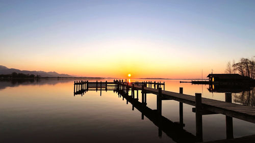 Pier over sea against sky during sunset