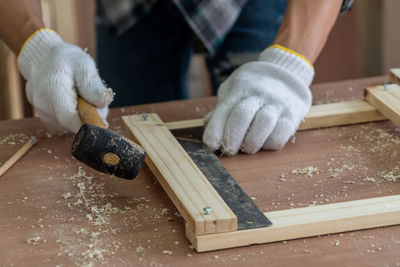 Close-up of man making wood on table