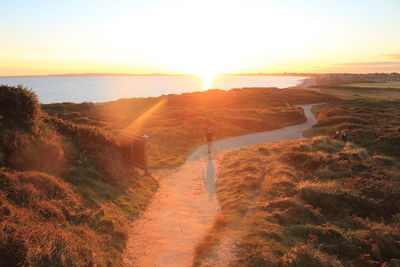 Scenic view of landscape at hengistbury head against sky during sunset