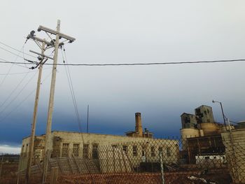 Low angle view of electricity pylon against sky