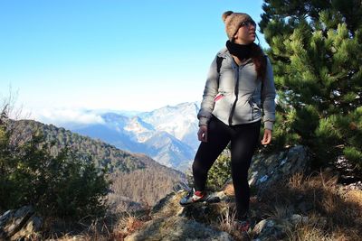 Full length of woman standing on mountain against sky