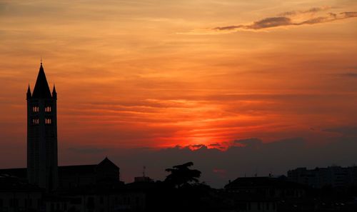 Silhouette buildings against orange sky