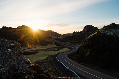 Winding road through mountains in evening