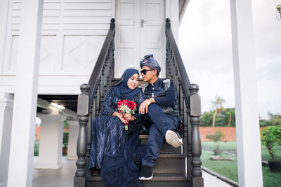 Young couple standing against wall