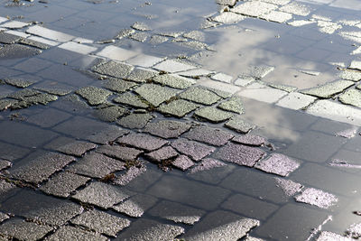 High angle view of puddle on cobblestone street during rainy season