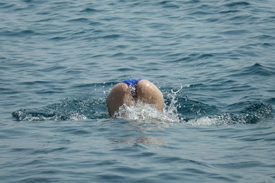 Low section of man swimming in sea