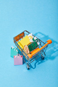High angle view of shopping cart on blue background