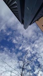 Low angle view of skyscrapers against cloudy sky