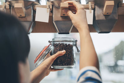 Woman filling mason jar with kidney beans at convenience store