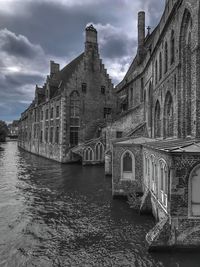 Arch bridge over river against buildings in city