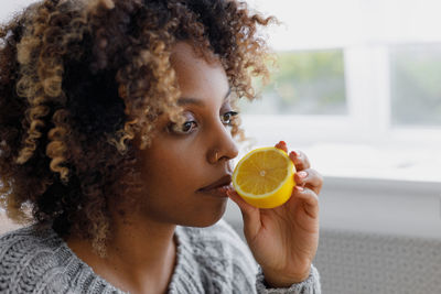 Young woman holding orange fruit