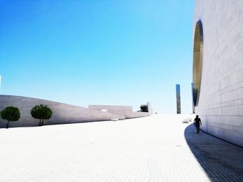 Man in city against clear blue sky