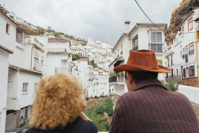 Rear view of man and woman looking at buildings in city