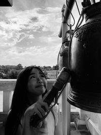 Portrait of young woman looking down against sky