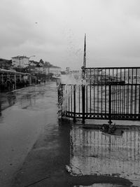 Pier on sea against buildings