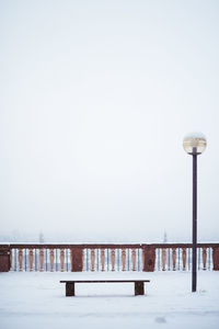 Street light on snow covered pier against sky