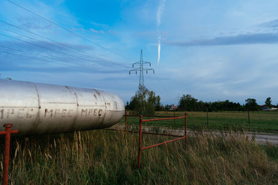 Electricity pylon on field against sky