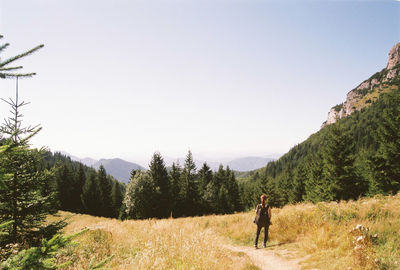 Woman standing on mountain against clear sky