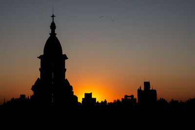 Silhouette of buildings against sky during sunset