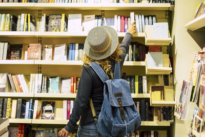 Rear view of woman standing in library