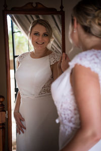 Portrait of smiling young woman standing at home