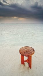 Lifeguard hut on beach against sky during sunset