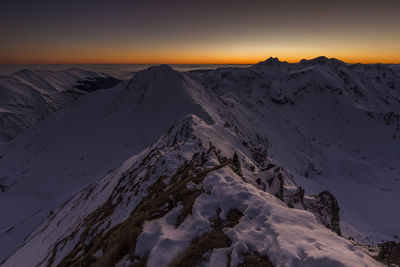 Scenic view of snowcapped mountains against sky during sunset