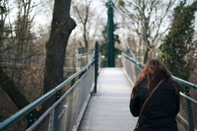 Rear view of woman on footbridge