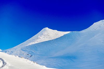 Scenic view of snowcapped mountains against clear blue sky