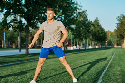 Full length of woman exercising on field