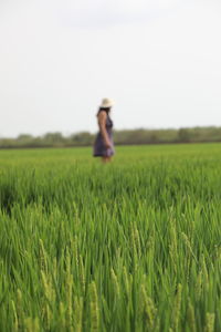 Woman standing on field against sky