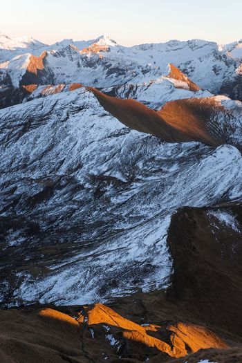 Scenic view of snowcapped mountains against blue sky